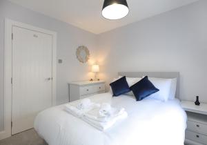 ein Schlafzimmer mit einem weißen Bett und Handtüchern darauf in der Unterkunft Smugglers Cove in North Berwick