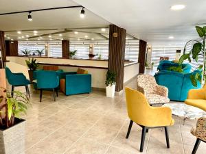 een wachtkamer met blauwe en gele stoelen bij BSA Gradina Hotel - All Inclusive & Private Beach in Goudstrand