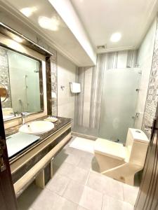 a bathroom with a sink and a toilet and a mirror at Narmiss Aparthotel in Unayzah
