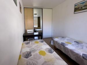 Habitación pequeña con 2 camas y espejo. en Nidos Laivas, en Nida