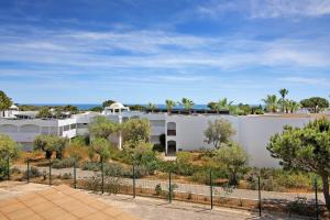 Un edificio blanco con árboles delante. en Yara Beach Apartments with Terrace, en Albufeira