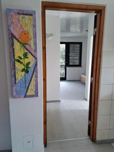 a hallway with a painting on the wall and an open door at Apartment Oase in Balatonszemes