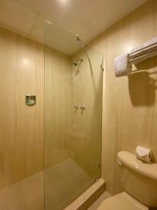 a bathroom with a glass shower with a toilet at Hotel Las Palmas Inn in Punto Fijo