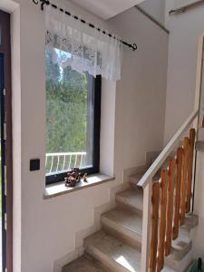 un escalier avec une fenêtre et un ensemble d'escaliers dans l'établissement Apartment Oase, à Balatonszemes