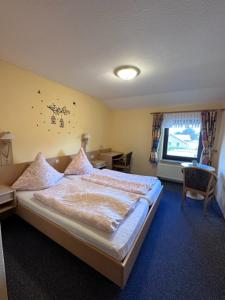 a bedroom with a bed and a television in it at Hotel Holtriemer Hof in Nenndorf