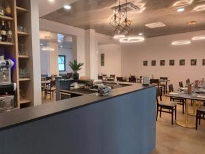 a restaurant with a counter and tables and chairs at Hotel Trieste in Senigallia