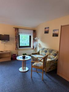 a living room with a couch and a table at Hotel Holtriemer Hof in Nenndorf