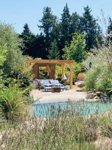 a gazebo with a couch in a garden at Le Nid de la Huppe in Noves