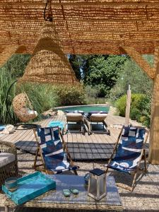 a patio with chairs and a table and a ping at Le Nid de la Huppe in Noves