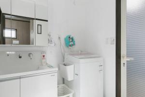 a white bathroom with a sink and a refrigerator at Vacation House Jo in Agarii +51 photos