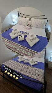 Un dormitorio con 2 camas con toallas y una muñeca. en Curti Granda, en Rescaldina