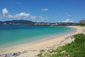 a beach with blue water and a city in the background at Vacation House Jo in Agarii