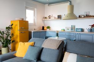 a living room with a blue couch and a yellow refrigerator at Amici Miei Makarska in Makarska