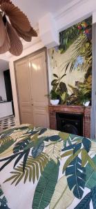 - une chambre avec un lit et une couverture recouverte de feuilles dans l'établissement Studio de charme au cœur de Lyon, à Lyon