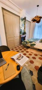 a room with a table with a laptop and a bed at Studio de charme au cœur de Lyon in Lyon