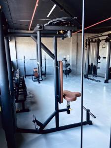 a room with a gym with a bench and weights at Golden Towers Hotel in Macaé