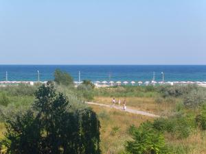 two people walking down a path near the beach at Hotel Zora in Kranevo