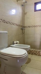 a bathroom with a toilet and a bath tub at Cabañas La Suyana in Tafí del Valle