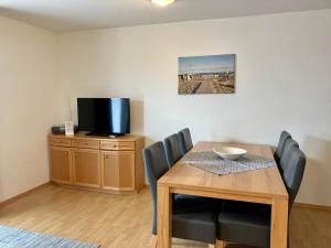 a dining room with a table and a tv at Clemens 1 in Wangerooge