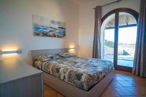 Un dormitorio con una cama y una ventana grande. en GREEN HILL BeB, en Alghero