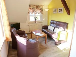 a living room with a couch and chairs and a table at Dat Spatzenhus 1 in Wangerooge