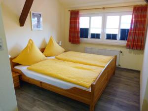 a bedroom with a bed with yellow sheets and a window at Dat Spatzenhus 1 in Wangerooge