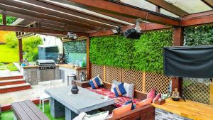 a patio with a table and a green wall at Cosy Luxurious Family Home in London +20 photos