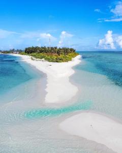 an island in the ocean with white sand and blue water at Oasis Village Fenfushi, Maldives in Fenfushi