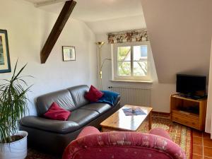 a living room with a leather couch and a table at Dat Spatzenhus 2 in Wangerooge