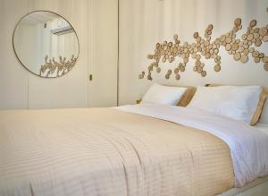 een slaapkamer met een groot wit bed en een spiegel bij Porto Cave-styled duplex in Porto