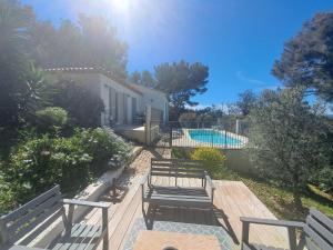 un grupo de bancos sentados junto a una piscina en Villa K Presqu ile de Giens, en Hyères