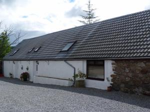 a white building with a gray roof at Broomhead Cottages in Dufftown