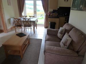 un soggiorno con divano e tavolo di Broomhead Cottages a Dufftown