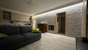 a living room with a couch and a kitchen at La Casa di Gemma in Villa Vomano