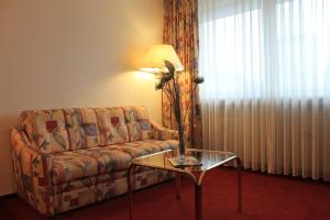 a living room with a couch and a table at City Hotel Essen in Essen