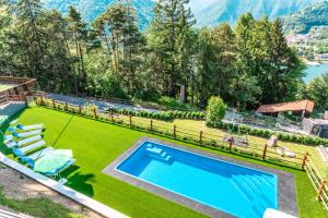 an image of a backyard with a swimming pool and grass at Casa Panorama - Ledro House in Pieve Di Ledro