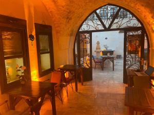 a room with tables and chairs in a building with a doorway at BABIL ANTIQUE HOTEL in Urfa