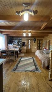 Schlafzimmer mit einem Bett, einem Tisch und einem Teppich in der Unterkunft Будиночок в Карпатах in Jaremtsche