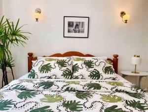 uma cama com um edredão verde e branco em Flip Flop In Townhouse em Bangkok