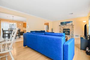 un sofá azul en una sala de estar con chimenea en Lakefront Bliss, en Pocono Summit