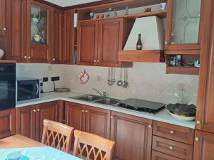 a kitchen with wooden cabinets and a sink at S'Altura, dall'alto di Nuoro in Nuoro