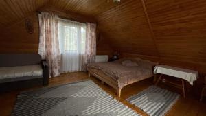 sypialnia z łóżkiem i oknem w kabinie w obiekcie Будиночок в Карпатах w Jaremczach
