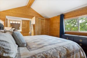 1 dormitorio con 1 cama grande en una habitación con paredes de madera en Scenic Sunset en Osage Beach