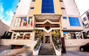 a building with stairs leading to the front of a hotel at Diaudi Hotel in São José