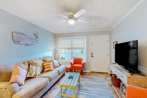 sala de estar con sofá y TV de pantalla plana en Sunchase #208, en Gulf Shores