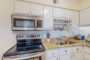 a kitchen with a stove and a microwave at Sunchase #208 in Gulf Shores