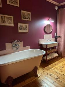 a bathroom with a bath tub and a sink at Moulin de Joumard, chambres et table d'hôtes de charme , jacuzzi, sauna, piscine et bain nordique 