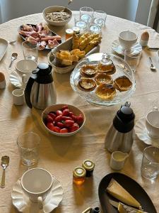 une table recouverte de assiettes et de bols de nourriture dans l'établissement Moulin de Joumard, chambres et table d'hôtes de charme , jacuzzi, sauna, piscine et bain nordique, 