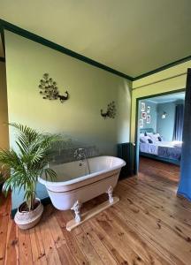 a bath tub in a room with a bedroom at Moulin de Joumard, chambres et table d'hôtes de charme , jacuzzi, sauna, piscine et bain nordique 