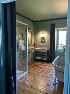 a bathroom with a tub and a sink and a mirror at Moulin de Joumard, chambres et table d'hôtes de charme , jacuzzi, sauna, piscine et bain nordique 